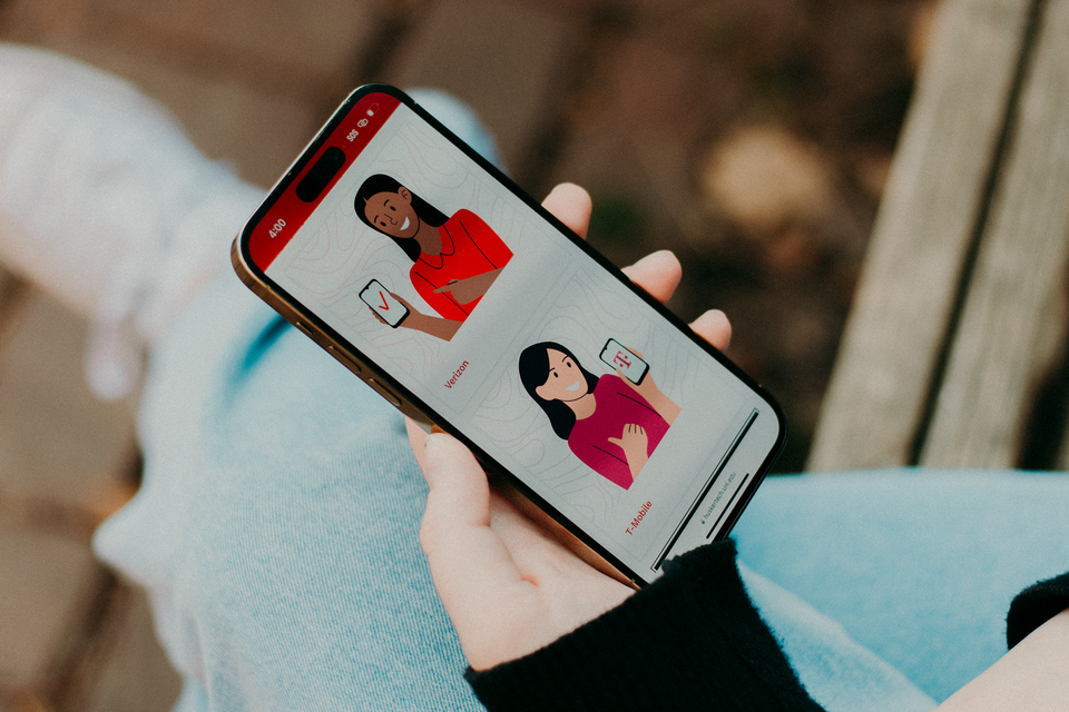 Person holding a smartphone displaying colorful illustrations of women on the screen.